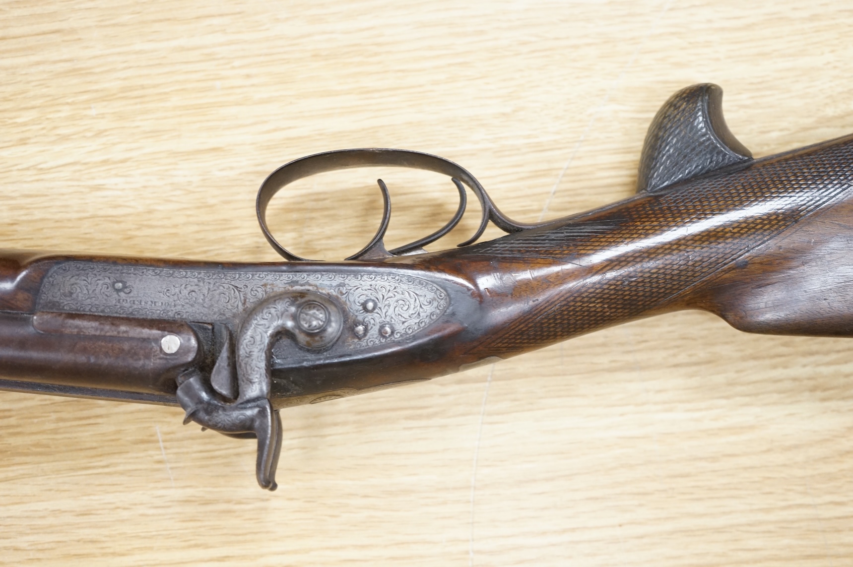 A double barrel 12 bore percussion sporting gun, signed Cocksedge, Hadleigh, with engraved locks and iron furniture, half stocked chequered grip with finger support in wood above guard